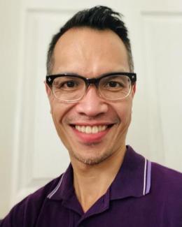 Chinese American male wearing black glasses, wearing purple polo shirt