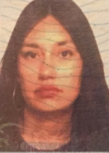 This is a passport photograph of a person with dark brown hair and brown eyes. 