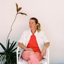 An artist sitting next to a plant.