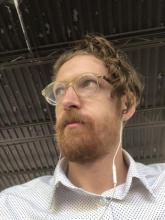 Photo of Nick Sturm wearing glasses and white shirt.