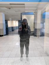 picture of a reflection of a person standing in an abandoned shopping mall